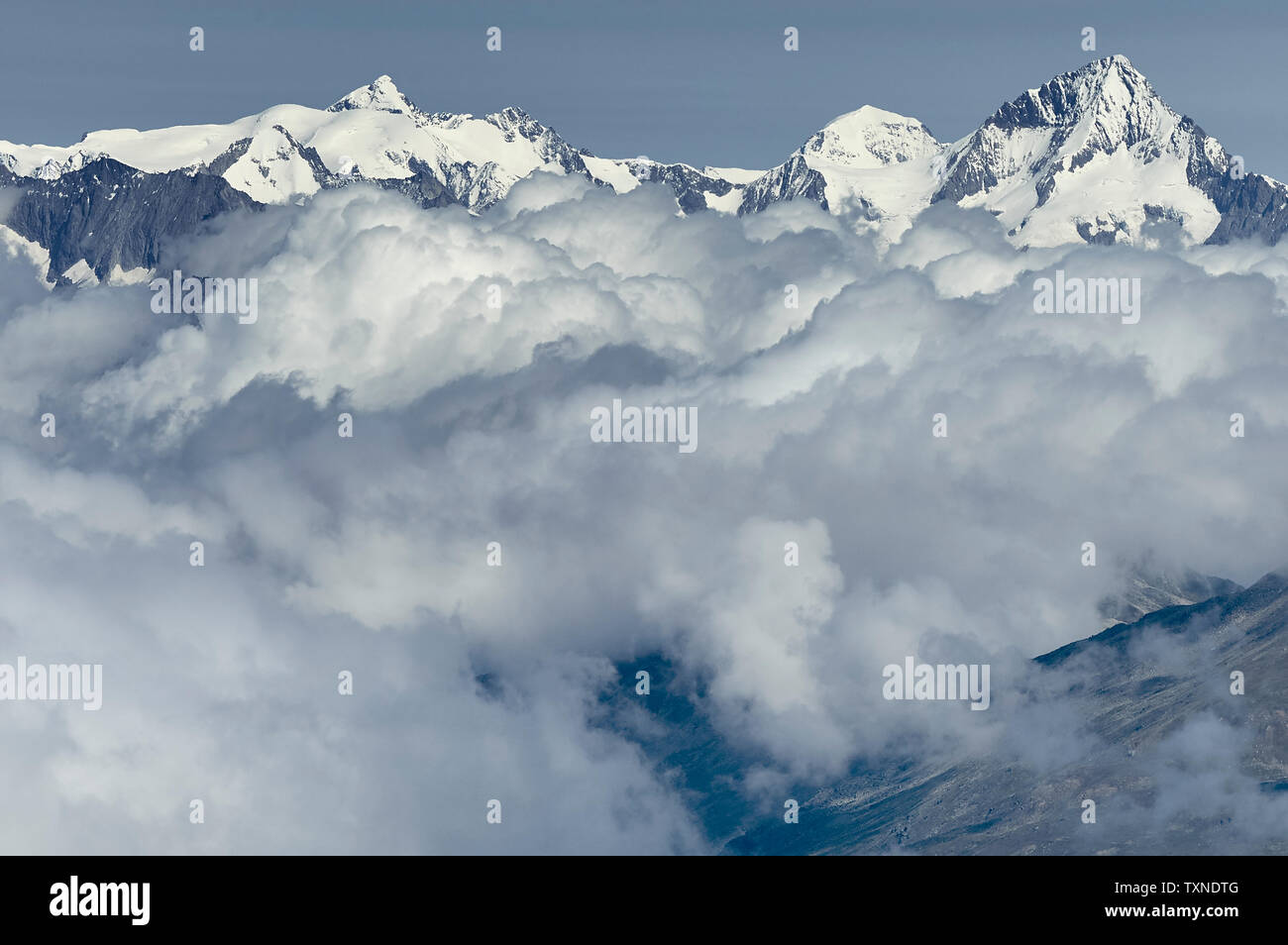 Capa de nubes cerca de la parte superior de la cordillera, Saas-Fee, Valais, Suiza Foto de stock