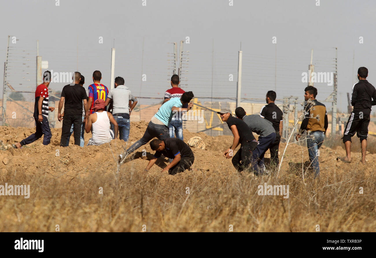 Tirar piedras palestinas como enfrentamientos con soldados israelíes durante una protesta contra el bloqueo de Gaza, cerca de la valla fronteriza, al este de Khan Yunis, en el sur de la Franja de Gaza el 19 de mayo de 2017. Fotos por Ismael Mohamad/UPI Foto de stock