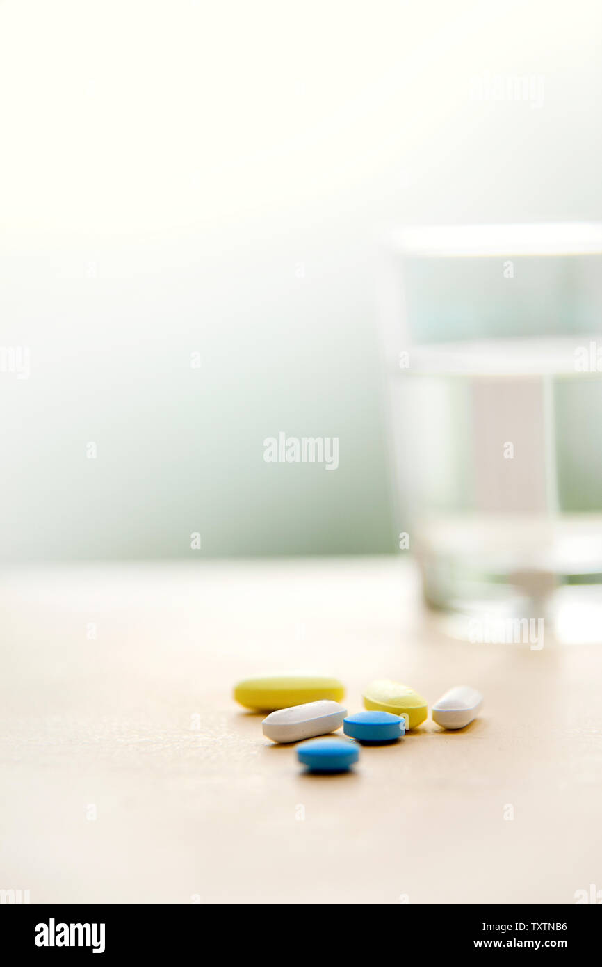 Medicamento junto a un vaso de agua. Foto de stock