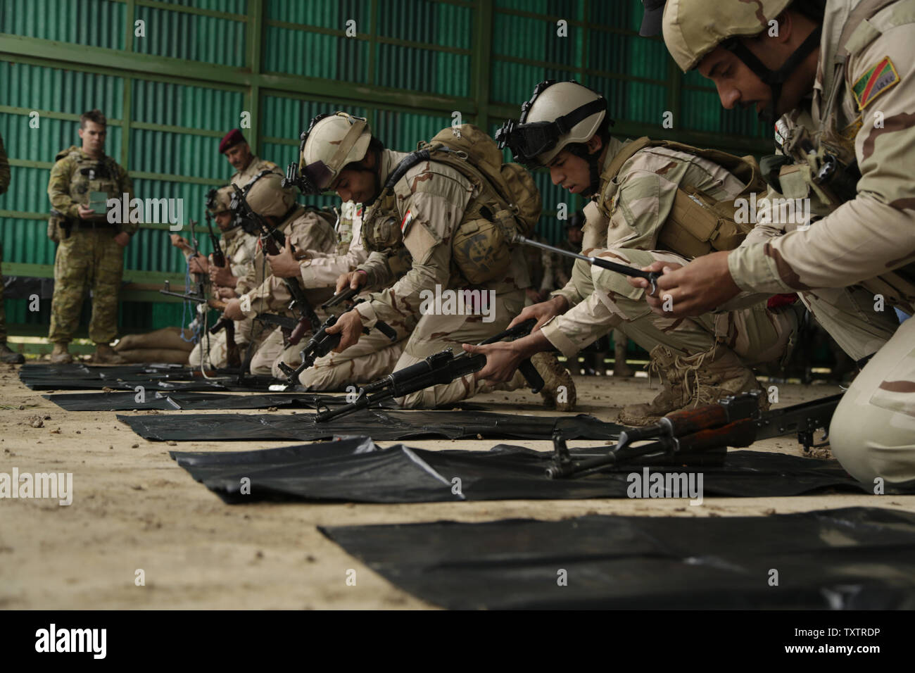 Los soldados iraquíes con el 4º Batallón, 23ª Brigada del ejército iraquí, práctica de desmontar sus rifles de asalto AK-47 para una evaluación de habilidades en Camp Taji, Iraq, el 28 de marzo de 2016. El Grupo de Tareas de Taji, realizó la evaluación de habilidades para medir la aptitud soldiersÕ en combate básico tareas. A través de asesorar y ayudar, y construyendo la capacidad del partner misiones, la Combined Joint Task Force C Funcionamiento inherentes ResolveÕs coalición multinacional ha capacitado a más de 19,9K personal para derrotar el estado islámico de Irak y el Levante. Foto por Sgt. Pablo Venta/EE.UU. Ejército/UPI Foto de stock