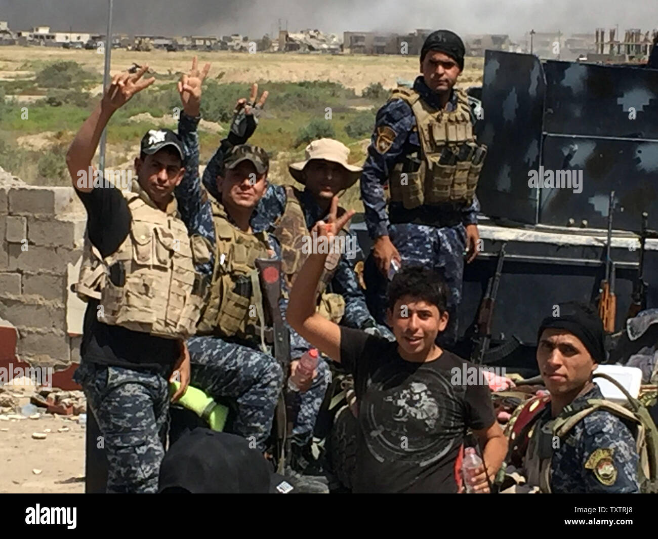 Los soldados de las fuerzas del gobierno iraquí flash signos victoria en Faluya Shuhada meridional del barrio durante una operación para retomar las áreas desde el Estado Islámico (ES) grupo, al oeste de Bagdad en Irak el 15 de junio de 2016. Las fuerzas iraquíes lanzaron una vasta ofensiva hace más de tres semanas para retomar Faluya, que se encuentra a sólo 50 km (30 millas) al oeste de Bagdad, y es uno de los principales bastiones de los jihadistas. Foto por Abbas Mohammed /UPI Foto de stock