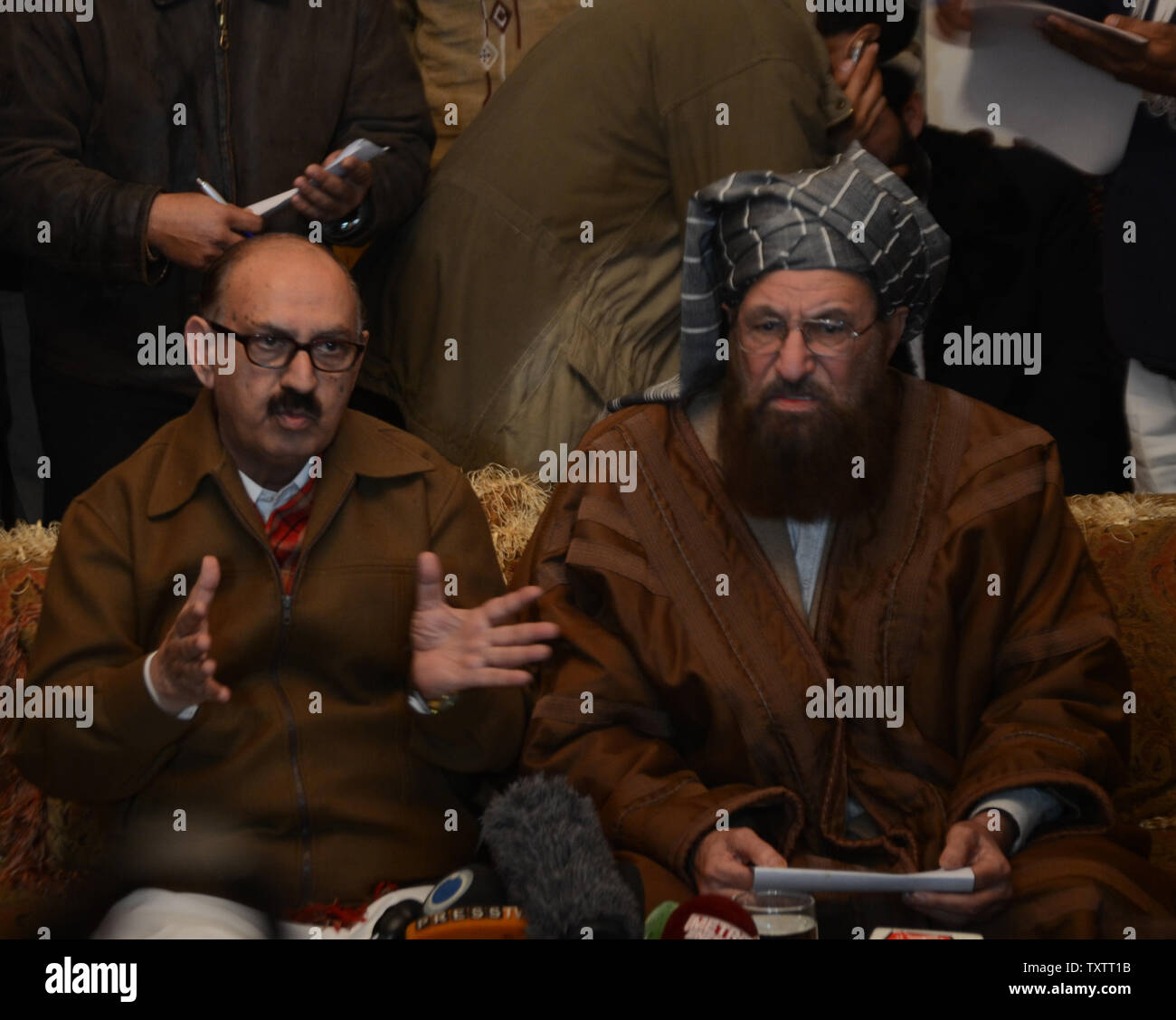 Tehreek-e-Taliban Pakistan (TTP) miembro del comité senior y líder del partido religioso Maulana Sami-ul-Haq (R) mira como Ayudante Especial del Primer Ministro de Pakistán Irfan Siddiqui (L), habla durante una conferencia de prensa conjunta tras su reunión en el Khyber Pakhtunkhwa Housen en Islamabad, Pakistán, el 6 de febrero de 2014. Los funcionarios del gobierno paquistaní y los representantes de los talibanes se reunieron para una primera ronda de conversaciones encaminadas a poner fin a los militantes' sangrienta rebelión de siete años. UPI/Sajjad ALi Qureshi Foto de stock