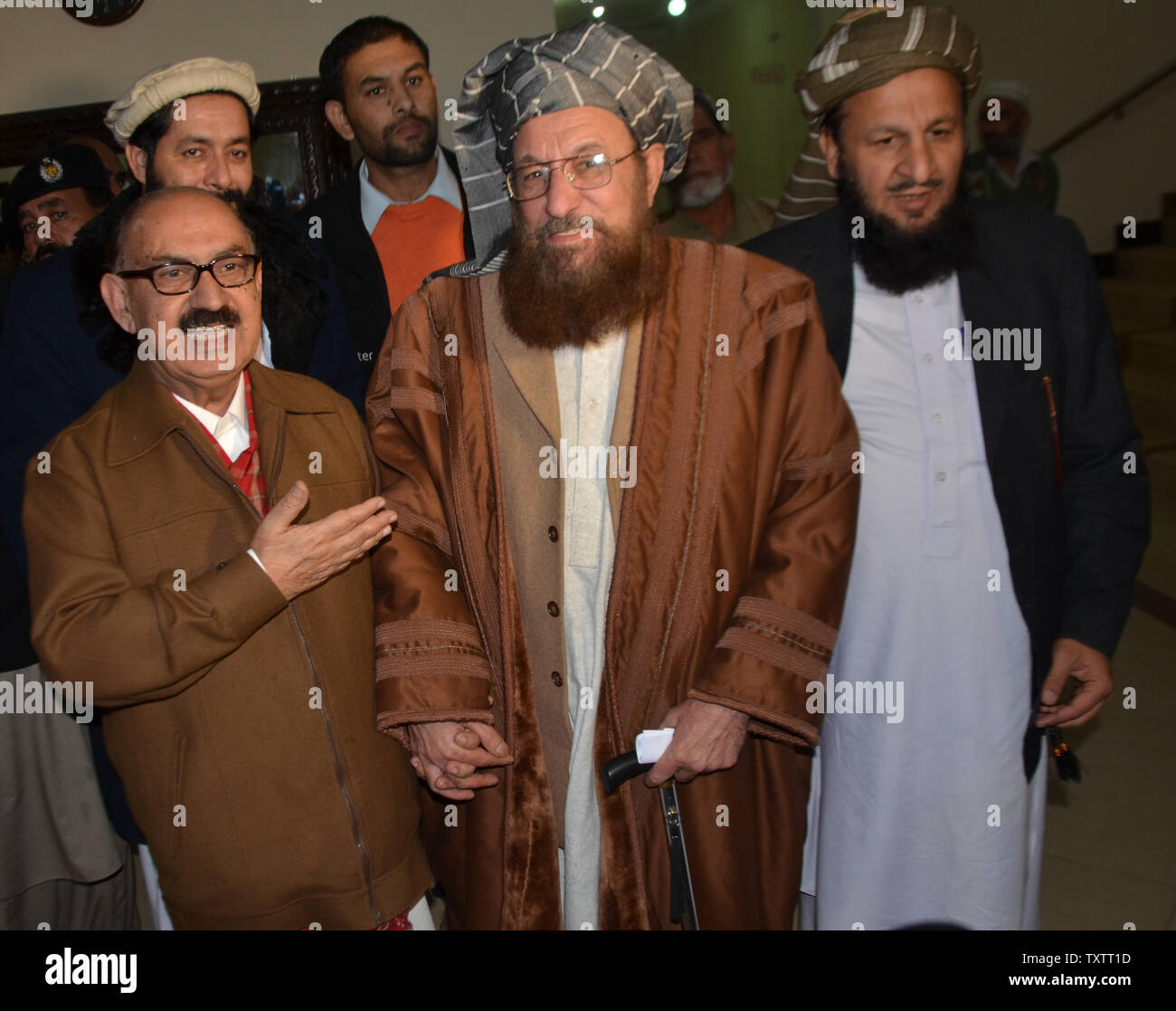 Tehreek-e-Taliban Pakistan (TTP) miembro del comité senior y líder del partido religioso Maulana Sami-ul-Haq (R) se da la mano con el Asistente especial para el primer ministro de Pakistán Irfan Siddiqui, después de su reunión en la Casa de Khyber Pakhtunkhwa en Islamabad, Pakistán, el 6 de febrero de 2014. Los funcionarios del gobierno paquistaní y los representantes de los talibanes se reunieron para una primera ronda de conversaciones encaminadas a poner fin a los militantes' sangrienta rebelión de siete años. UPI/Sajjad ALi Qureshi Foto de stock