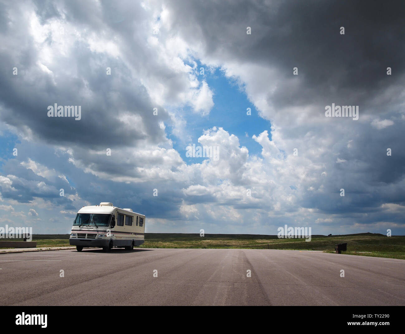 Una recreación vehical está estacionado en una parada de descanso de la carretera y el mirador en la pradera de Nebraska bajo un gran cielo con nubes dramáticas. Foto de stock