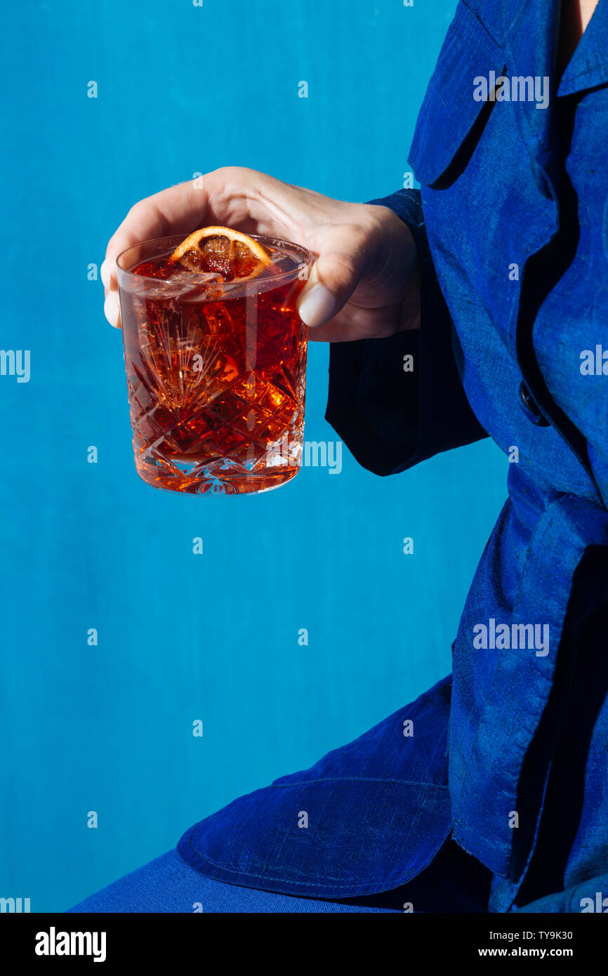 Mujer y Negroni cóctel con gin, amarga y vermut. Colorido y moderno. Foto de stock