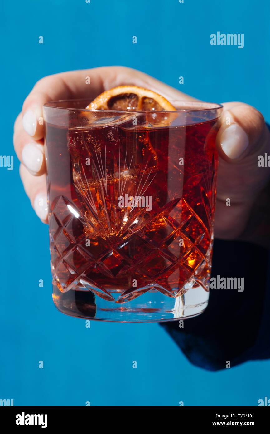 Mujer y Negroni cóctel con gin, amarga y vermut. Colorido y moderno. Foto de stock