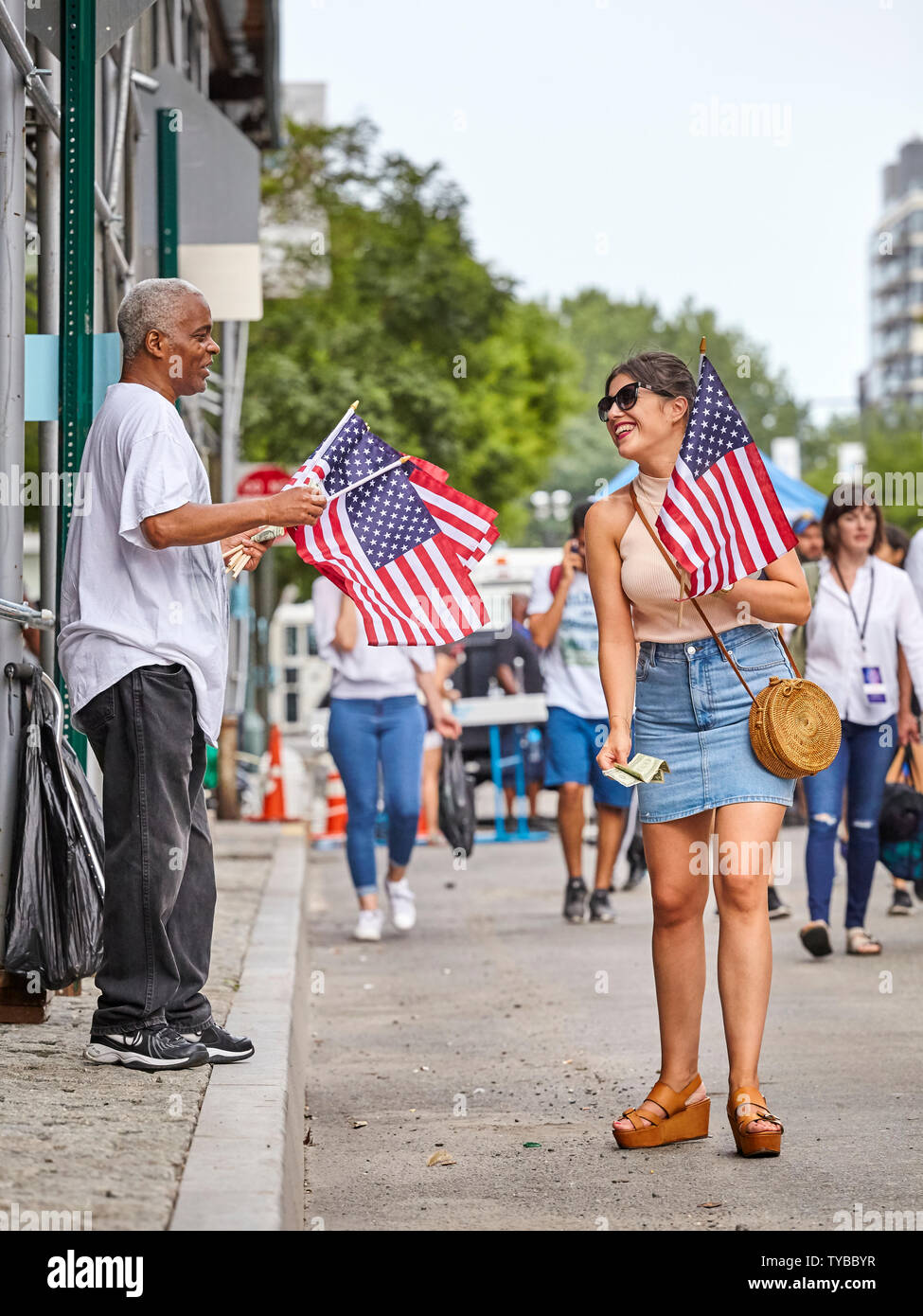 Nueva York, Estados Unidos - Julio 04, 2018: la mujer compra bandera americana durante la fiesta federal en los Estados Unidos en conmemoración de la Declaración de la independencia. Foto de stock