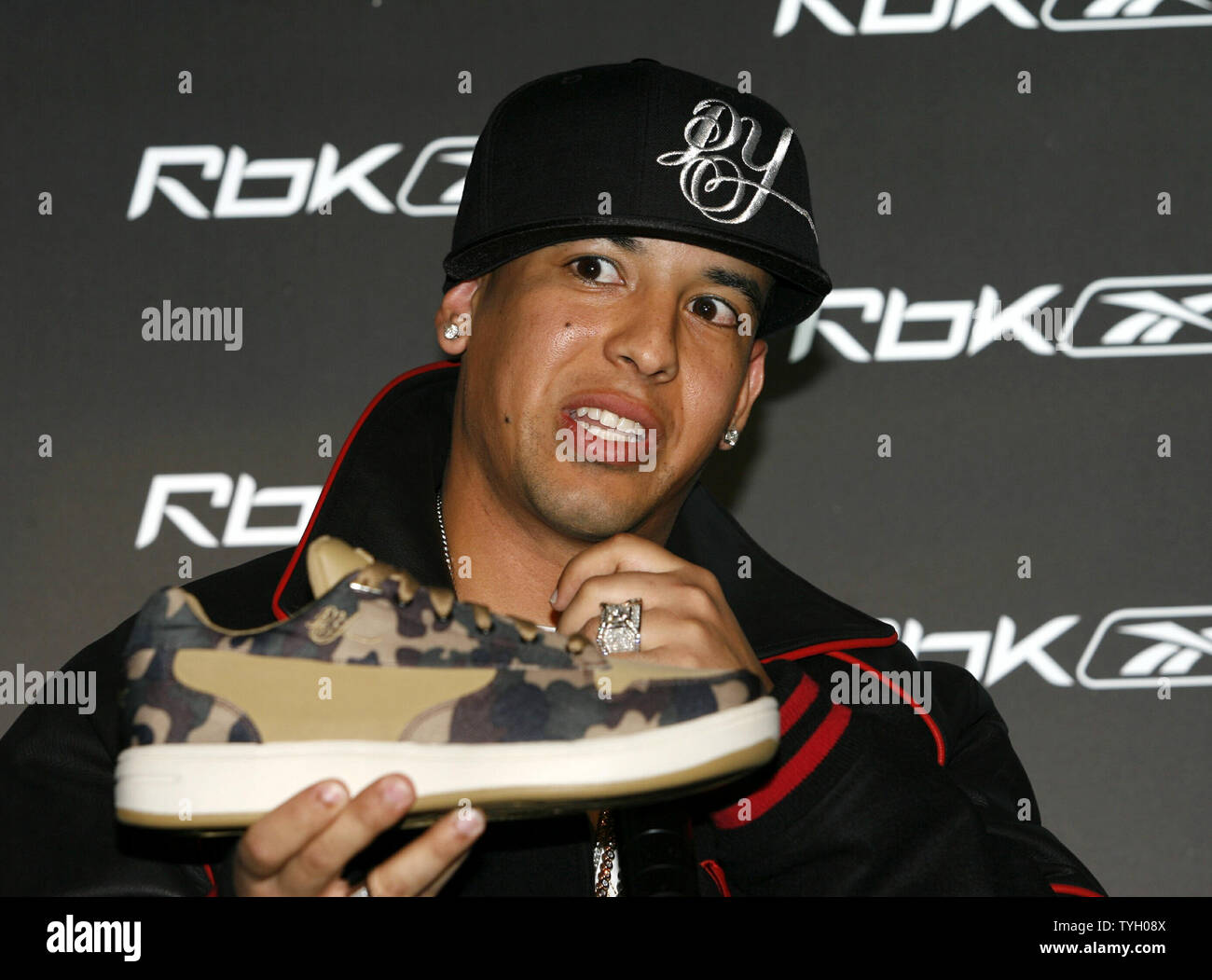 Daddy Yankee responde una pregunta sosteniendo sus nuevas zapatillas de  deporte en el Reebok RBK ahora jugando a conferencia de prensa en la carpa  en la Ciudad de Nueva York el 8