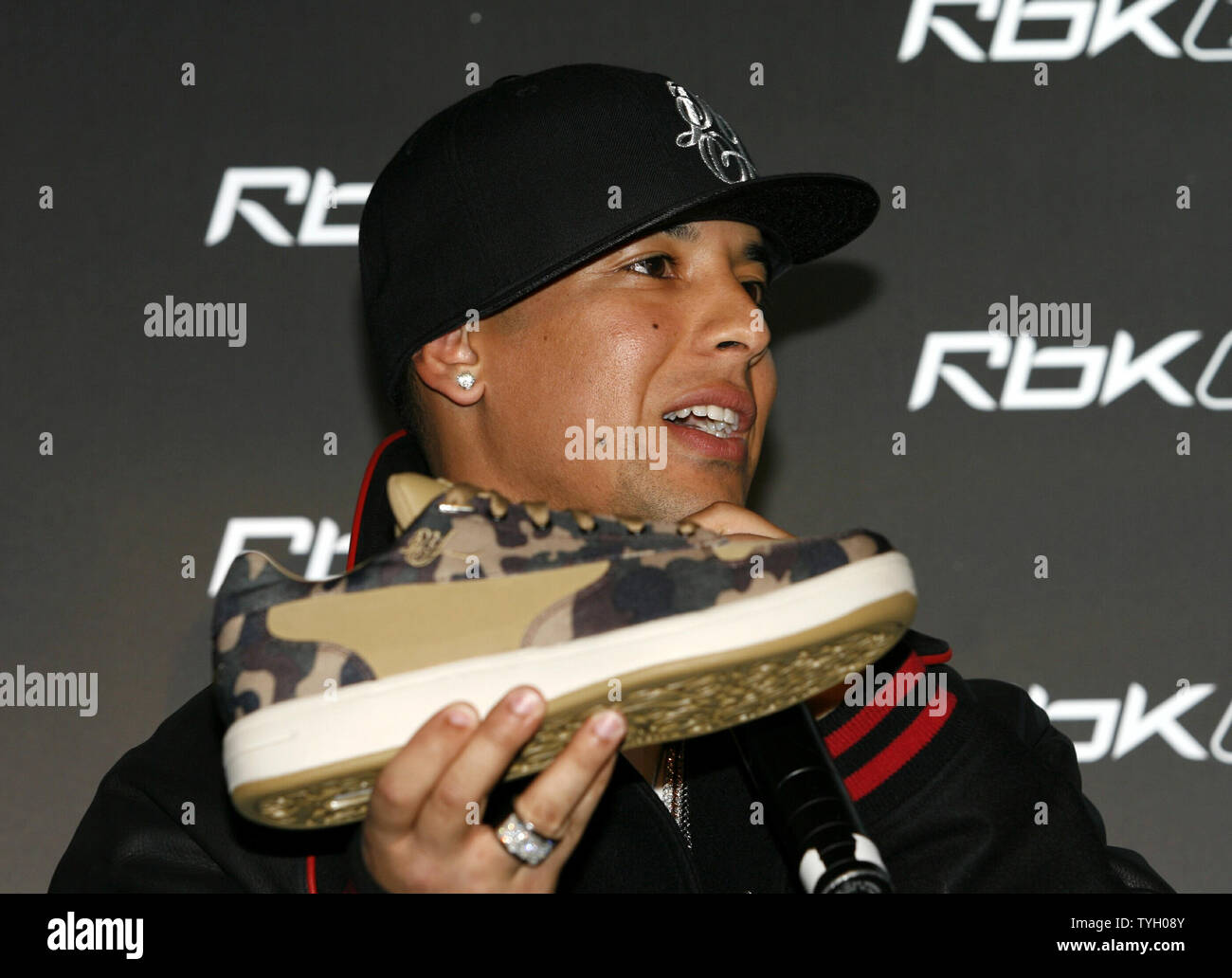 Daddy Yankee posa con su nueva zapatilla en el Reebok RBK ahora jugando a  conferencia de prensa en la carpa en la Ciudad de Nueva York el 8 de marzo  de 2006. (