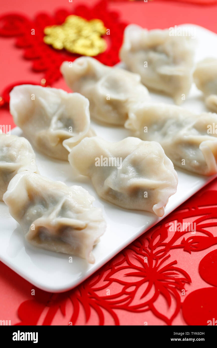 Primavera Festivl dumplings y papel cortado sobre fondo rojo. Foto de stock