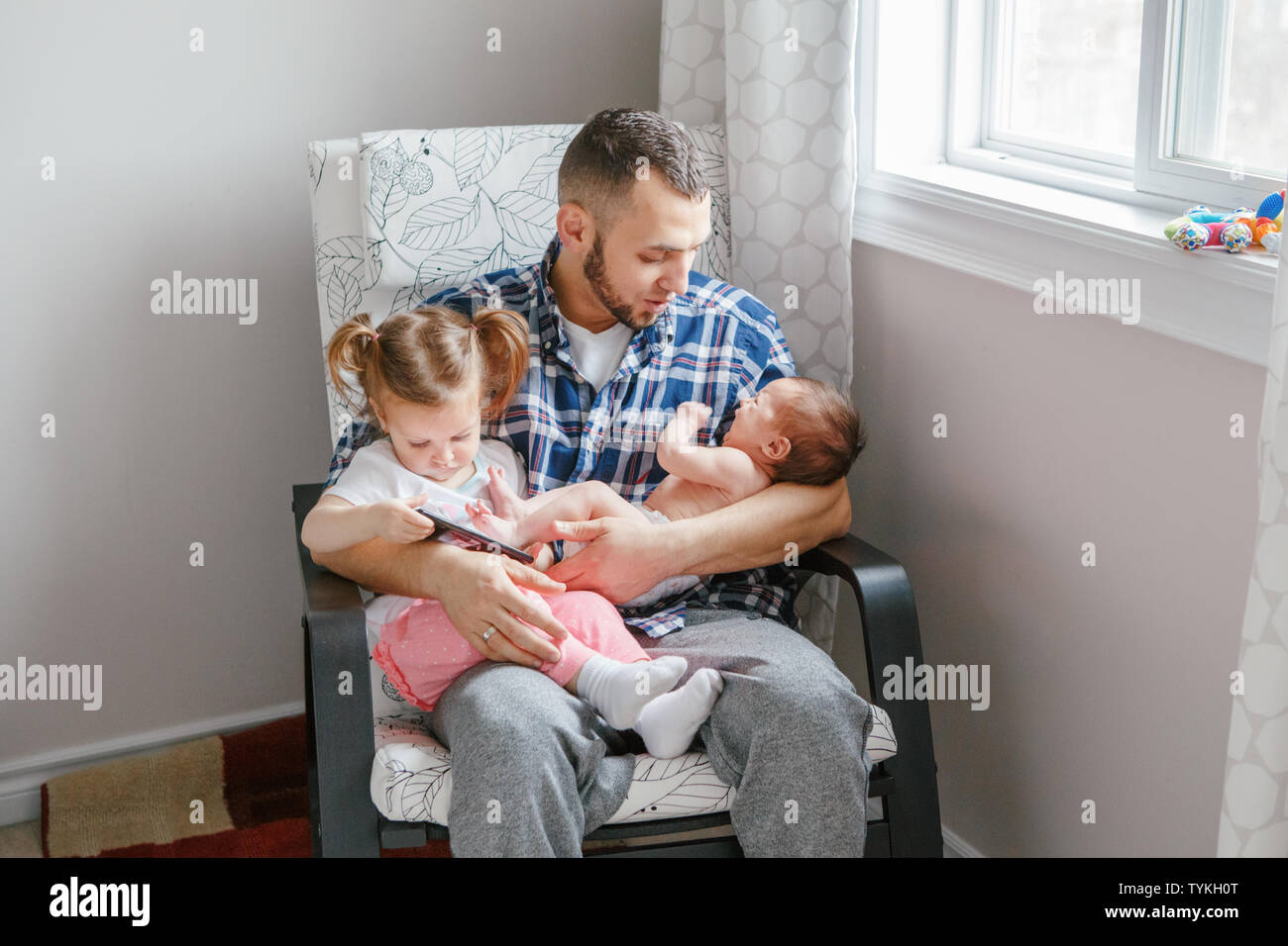 Padre Caucasico Papa Sentado Con Un Nino Pequeno Hija Y Recien Nacido Hijo Viendo Dibujos Animados En El Smartphone Candido Autentico Estilo De Vida De La Familia El Pecado Fotografia De Stock
