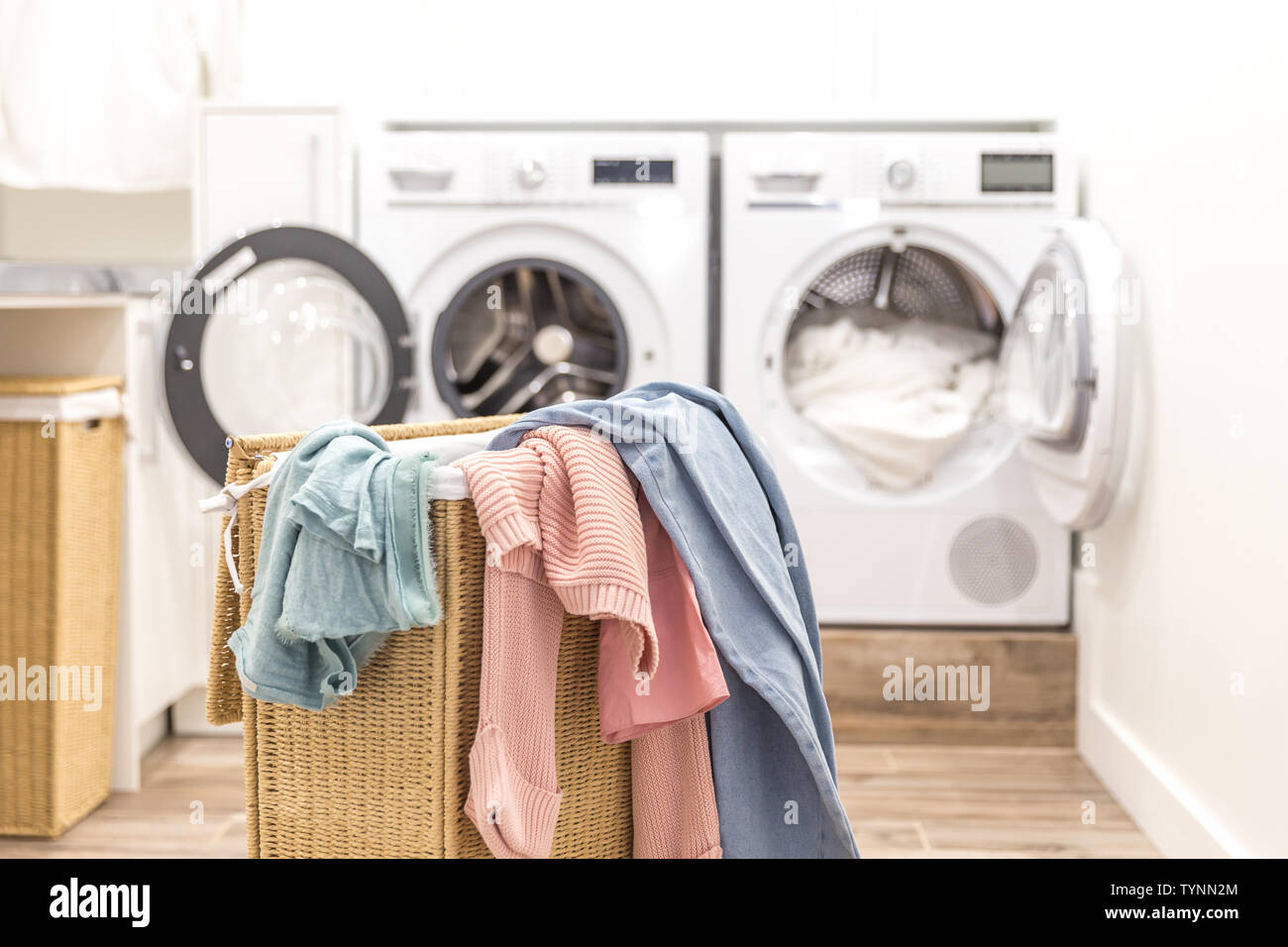 Cesta con la ropa sucia de lavandería con lavadoras y secadoras con monedas  en el fondo Fotografía de stock - Alamy