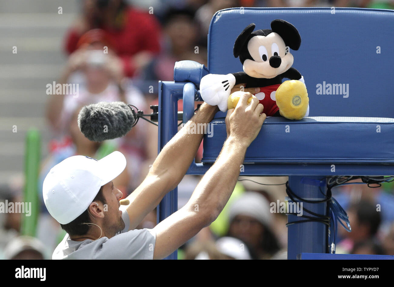 Nicolas Djokovic pone un peluche de Mickey Mouse en los árbitros bench en Arthur Ashe Kids día antes del US Open de tenis Campeonato en el USTA Billie Jean King National Tennis