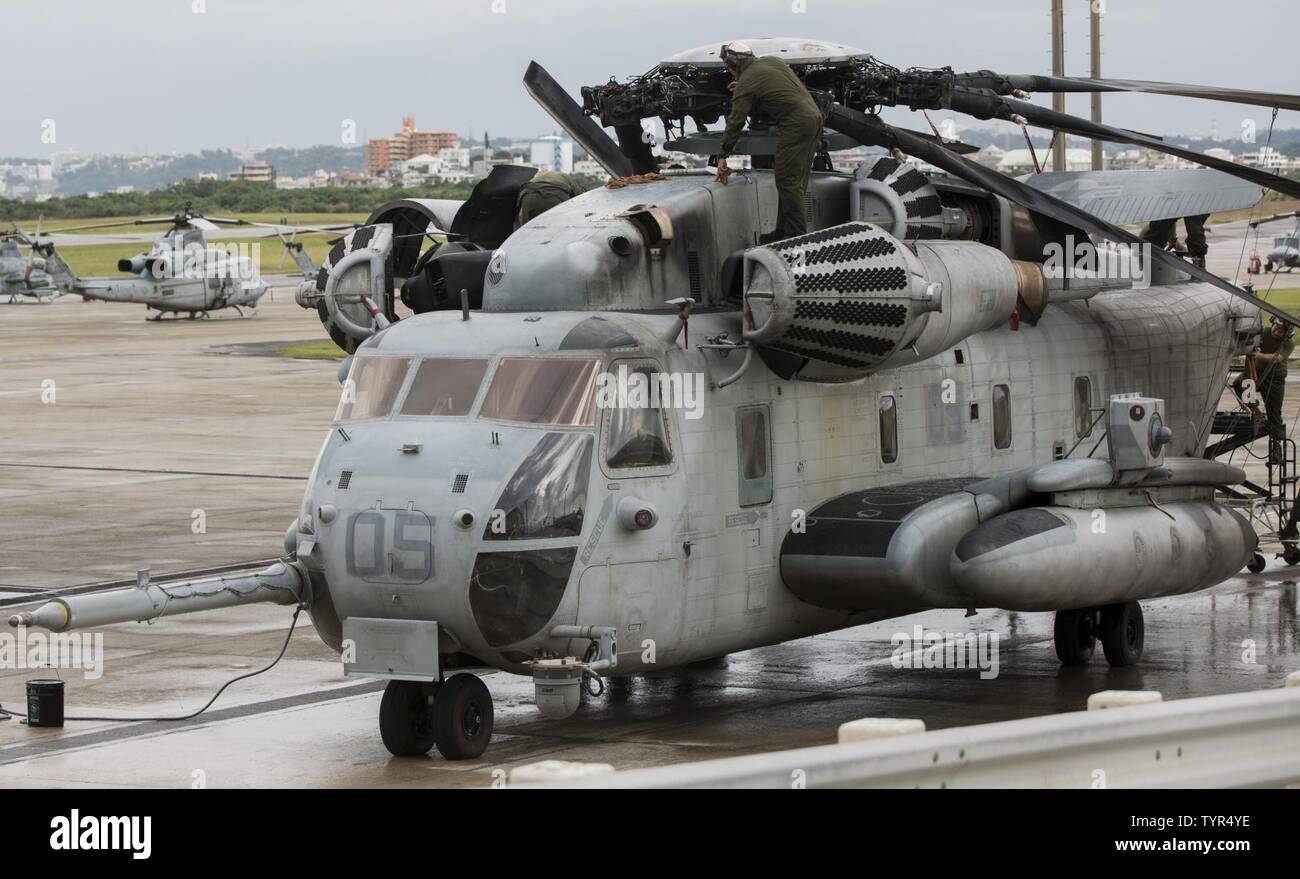 Marines estadounidenses con Marina escuadrón de helicópteros pesados (HMH) 465, aviones marinos Grupo 16, 3d Marine de alas de avión (MAW), barrido hacia abajo un semental CH-53 Mar después de un enjuague de agua dulce, en el Marine Corps Air Station Futenma, Okinawa, Japón, el 21 de noviembre, 2016. Los infantes de marina de HMH-465 coordinar enjuagues de agua dulce cada 14 meses para ayudar a mantener las capacidades y operaciones de 3D MAW. Foto de stock
