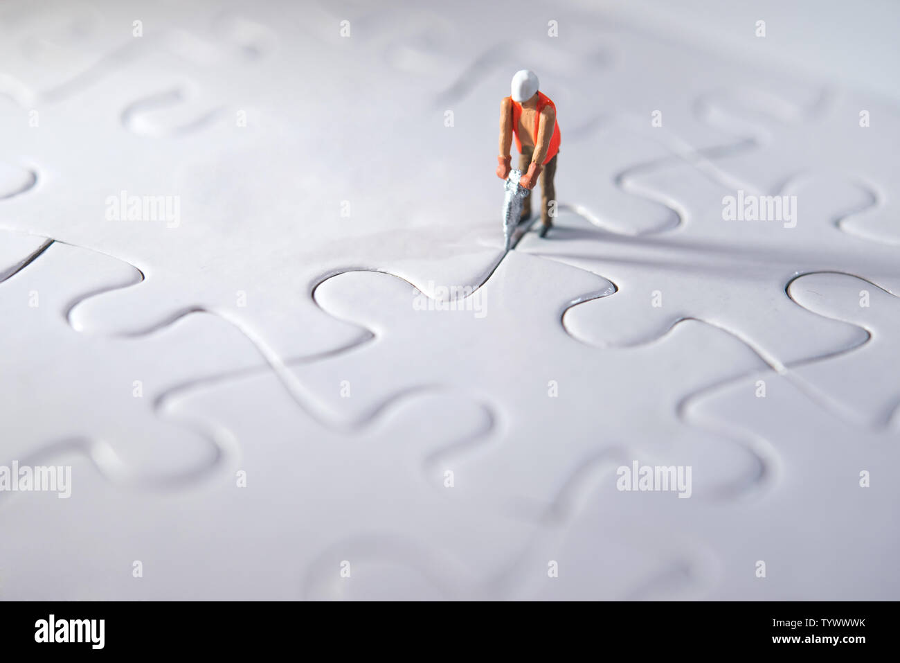 Persona en miniatura Construcción puzzles, haciendo camino para el equipo y el concepto de trabajo. Concepto de esfuerzo Foto de stock