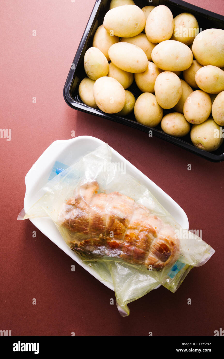 Raw caparisoned roastbeef carnes preparadas, con cerdo caul fat y el romero  en el interior de una bolsa de sous vide listos para ser cocinados con un  rooner con pequeñas patatas Fotografía