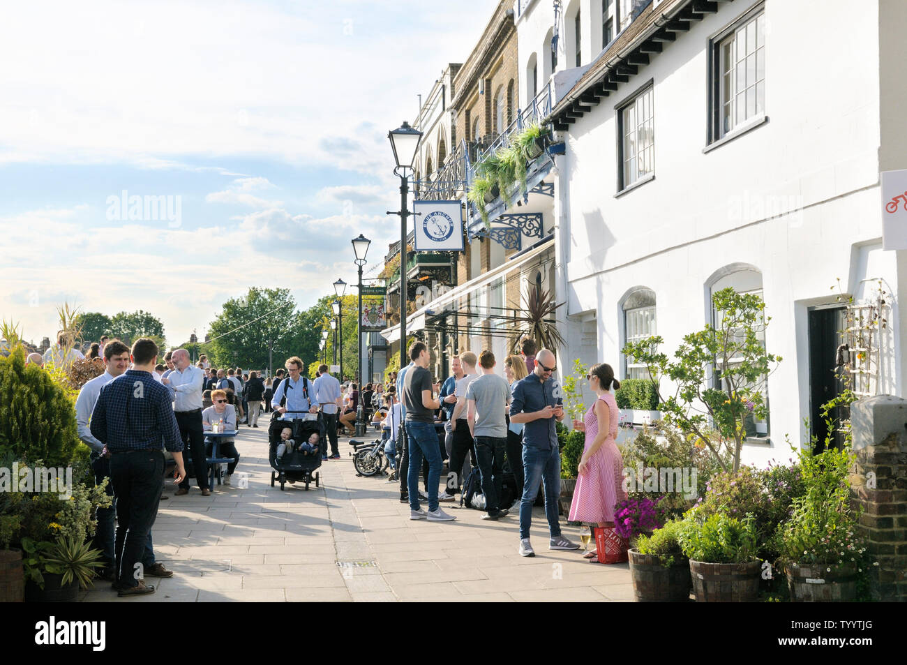 La gente disfruta de las bebidas en el sol fuera de la Blue Anchor y los brazos de Rutland pubs en Lower Mall, Hammersmith, Londres W6, Inglaterra, Reino Unido. Foto de stock