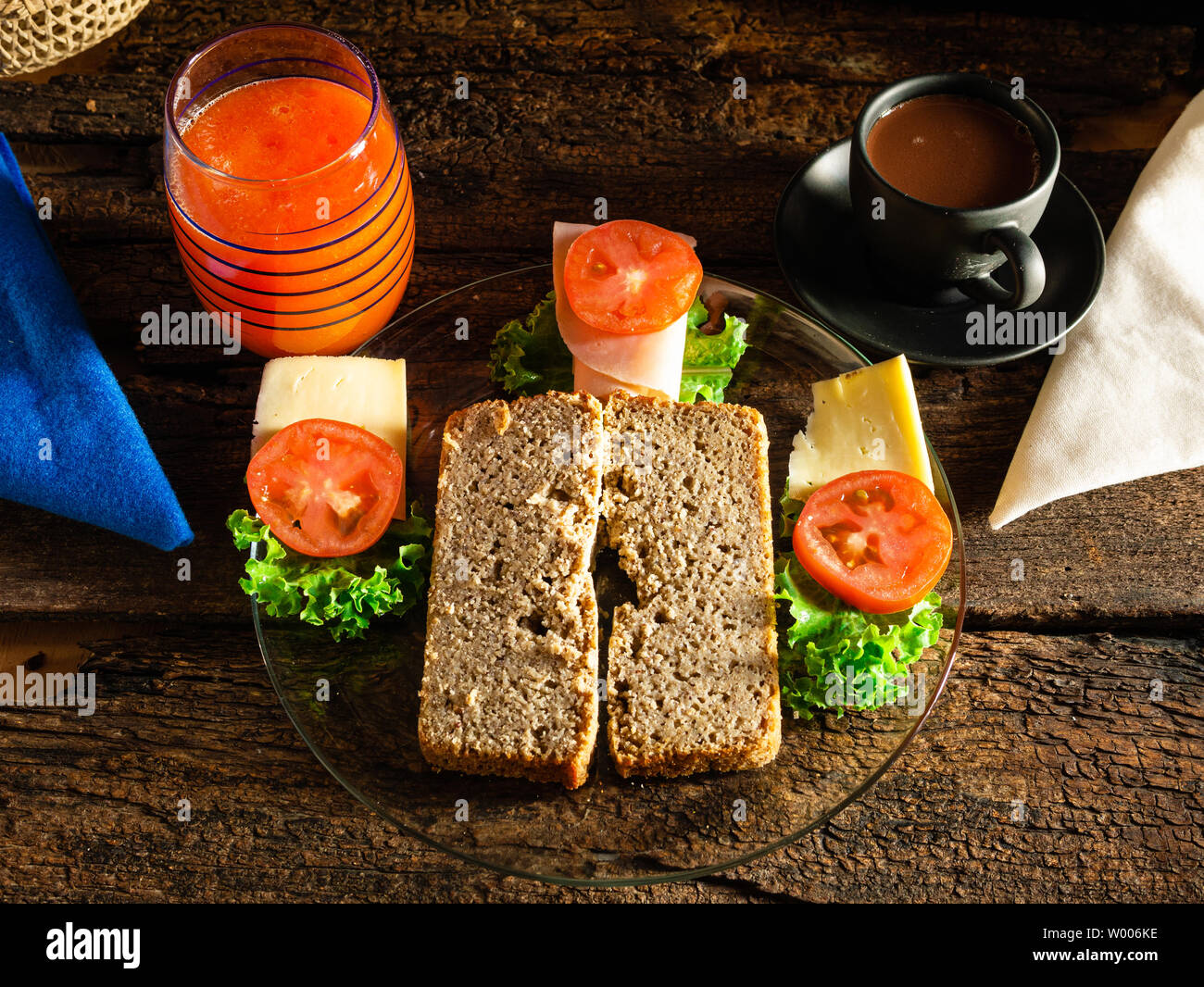 Pan casero sin gluten listo para preparar un sándwich con lechucha, queso,  jamón y tomate. Y, para beber, jugo de papaya y chocolate servido en un  Fotografía de stock - Alamy