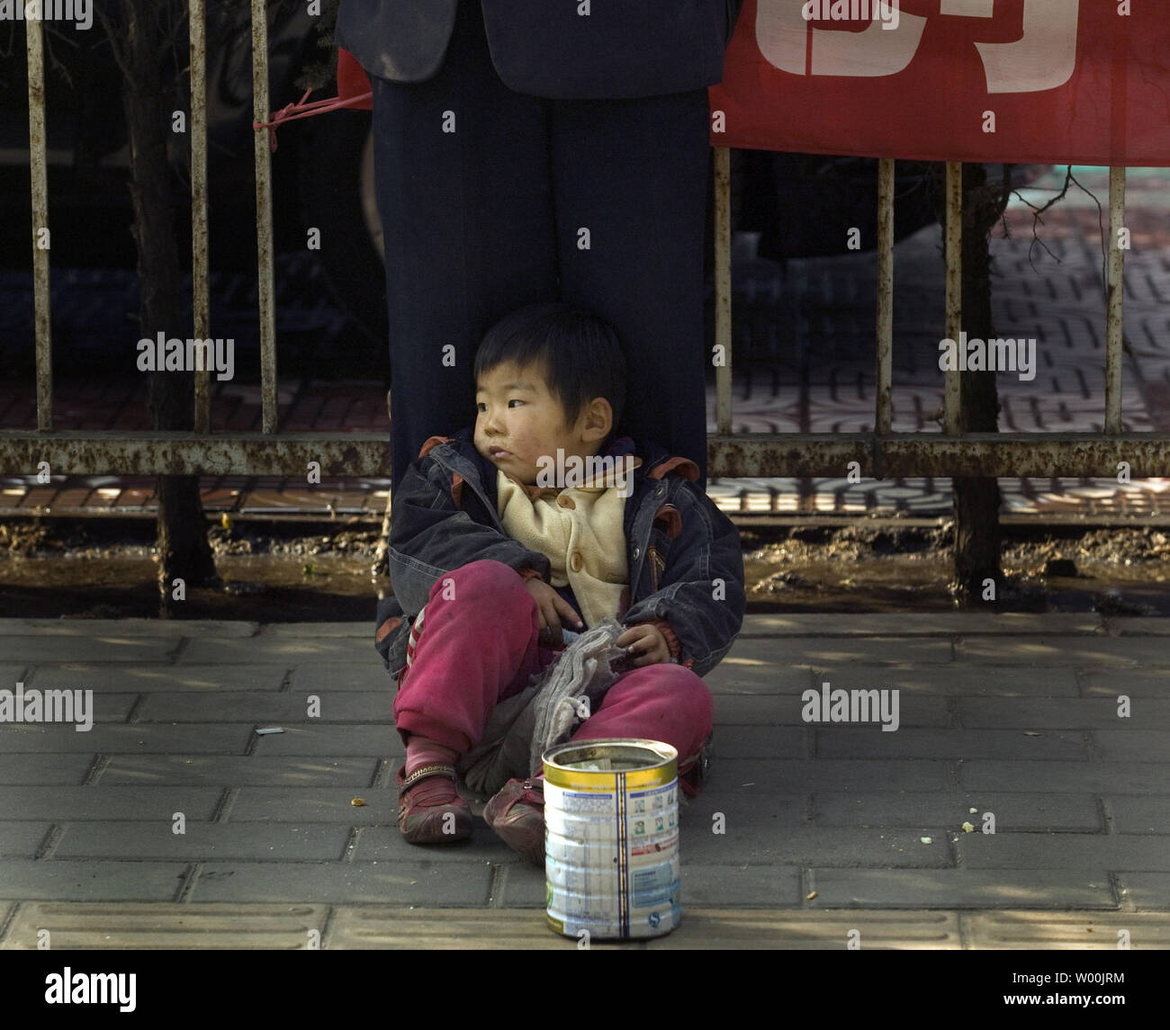 Un joven muchacho chino se sienta delante de un hombre ciego tocando la flauta en esperanzas de cambio repuesto recogida de los transeúntes, 4 de noviembre de 2008. China es llevar a cabo políticas más favorables para beneficiar a los pobres y a intensificar sus esfuerzos para aliviar la pobreza en el país, según el Vice Premier chino Hui Liangyu. (UPI Photo/Stephen afeitadora) Foto de stock