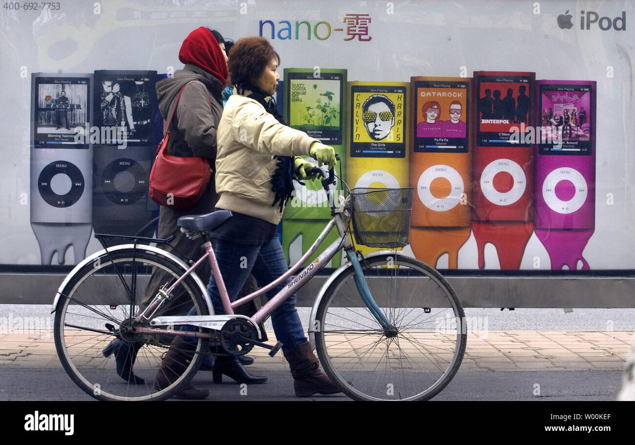 Las mujeres chinas atravesar una pequeña publicidad en vallas, el Apple  Ipod Nano en una estación de autobuses en Beijing el 23 de enero de 2009.  Gigante estadounidense de la tecnología Apple,