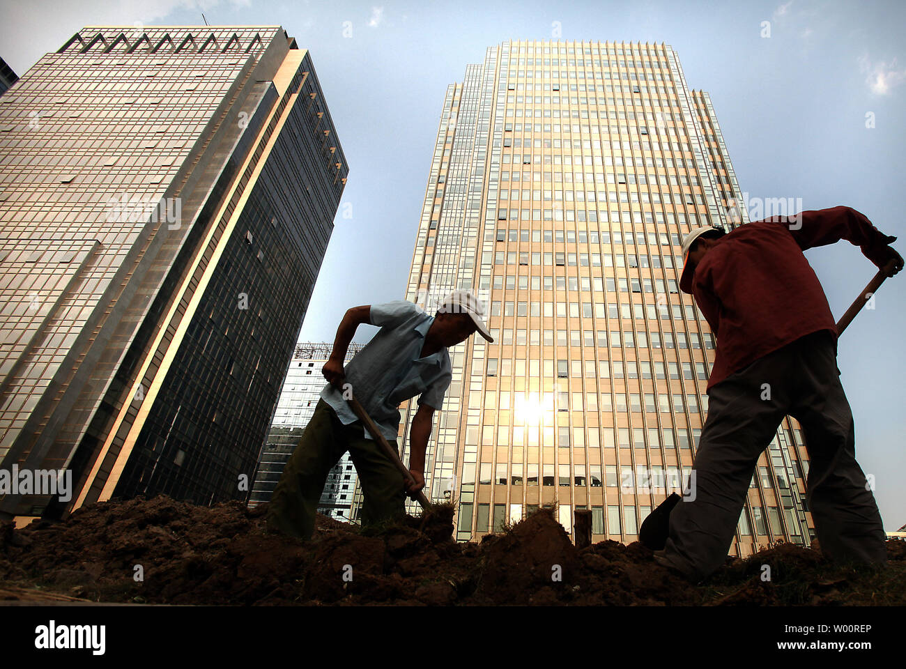 Trabajadores de la construcción chinos cavar una zanja delante de nuevos  complejos de negocios en Pekín en agosto 16, 2010. China es actualmente la segunda  economía más grande del mundo, después de