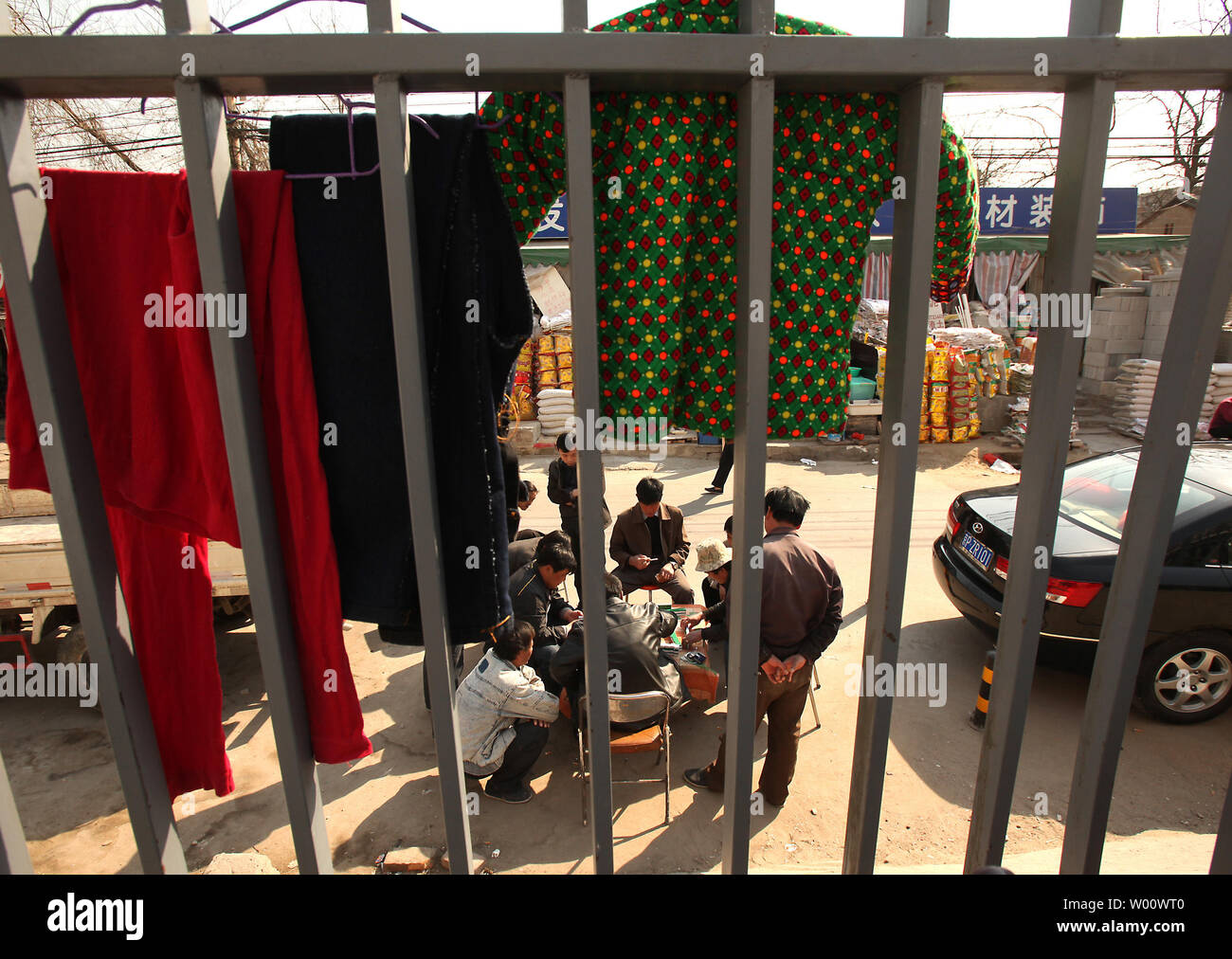 Hombres chinos juegan a cartas mientras espera para trabajar cerca de una esquina 'empleo' en Beijing el 28 de marzo de 2011. China, la tasa de desempleo urbano registrado - la única medida oficial de desempleo y que los economistas privados dicen no refleja plenamente el mercado de trabajo - seguía siendo algo más del 4 por ciento a finales de 2010. UPI/Stephen afeitadora Foto de stock