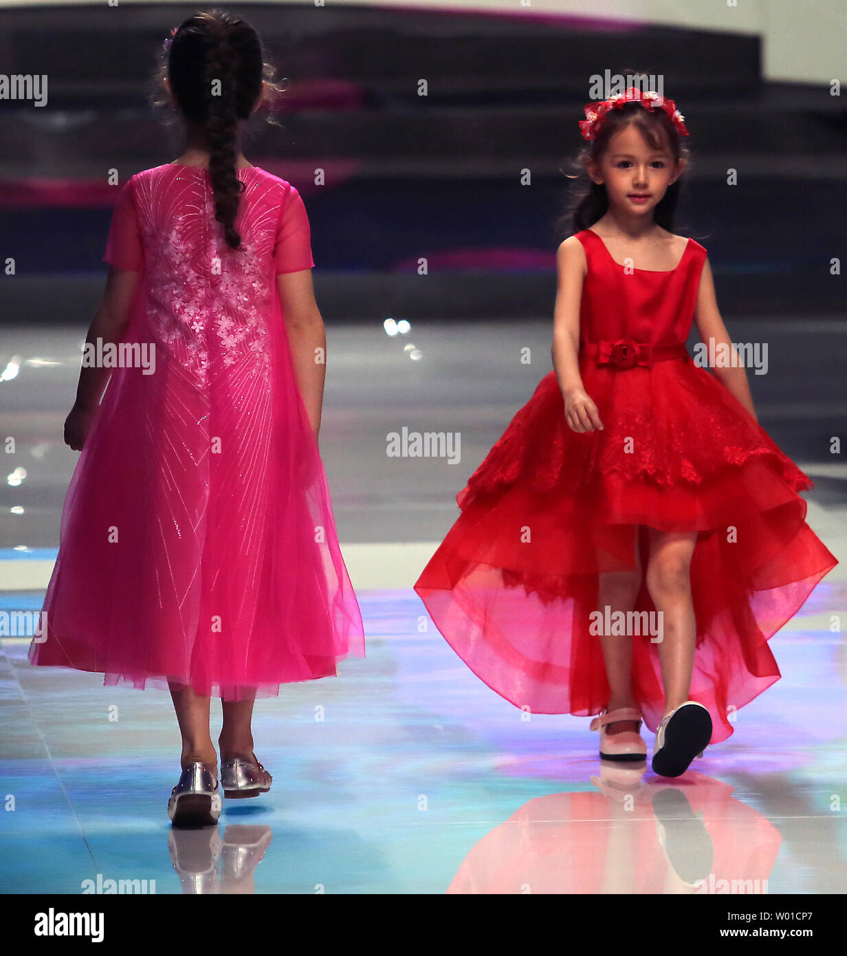 Niñas vestidos de modelo realizado por el diseñador de moda chino Ren Chunhua durante la Semana de la moda de China se celebró en Beijing el 26 de marzo de 2017.