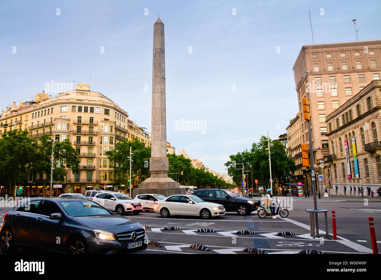 Obelisco al anochecer. Plaza Joan Carles I. Passeig de Gràcia y el cruce en diagonal, Barcelona, Cataluña, España. Foto de stock