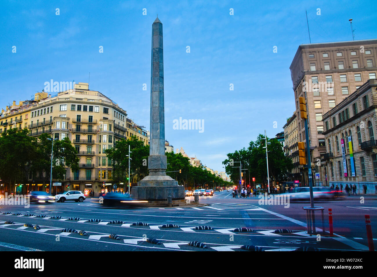Obelisco al anochecer. Plaza Joan Carles I. Passeig de Gràcia y el cruce en diagonal, Barcelona, Cataluña, España. Foto de stock