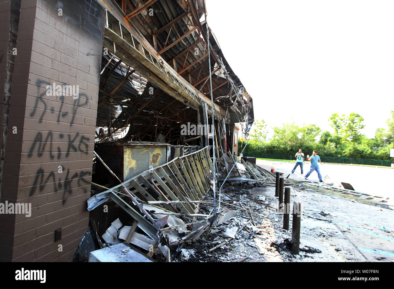 Los visitantes obtener una mirada más cercana a una gasolinera QuikTrip tras una noche de disturbios, saqueos e incendios provocados en Ferguson, Missouri, el 11 de agosto de 2014. La gente está enojada a causa de los disparos de la policía de Ferguson y la muerte de un adolescente negro desarmado Michael Brown, el 9 de agosto de 2014. En todos los alrededor de 20 empresas sufrieron daños tras una vigilia con velas se tornaron violentas. UPI/Bill Greenblatt Foto de stock