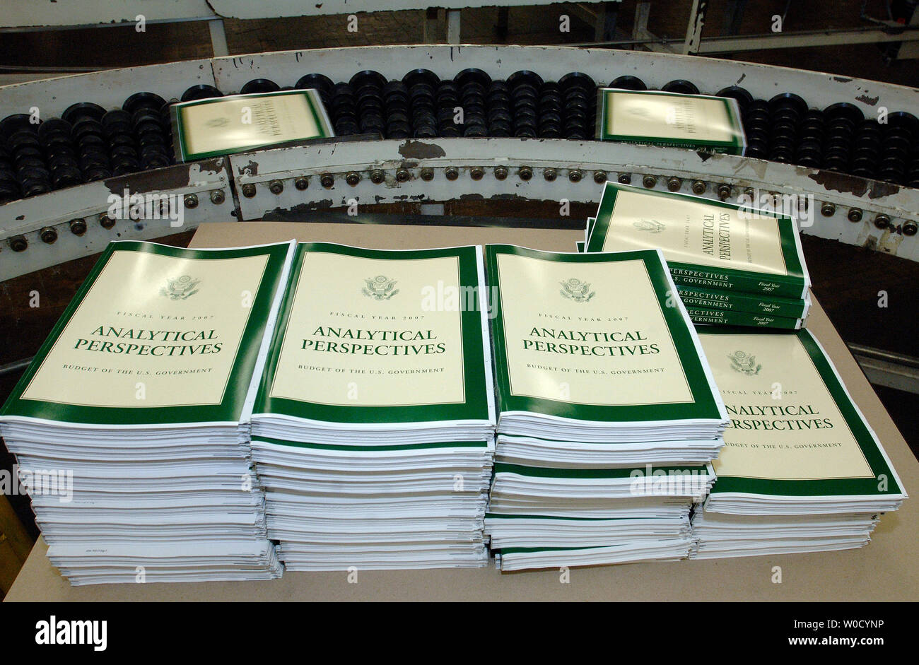 Copias del Año Fiscal 2007, el presupuesto del gobierno de Estados Unidos  se sientan en una mesa en la oficina de impresión del Gobierno, mientras  que otras copias ruedan hacia abajo por