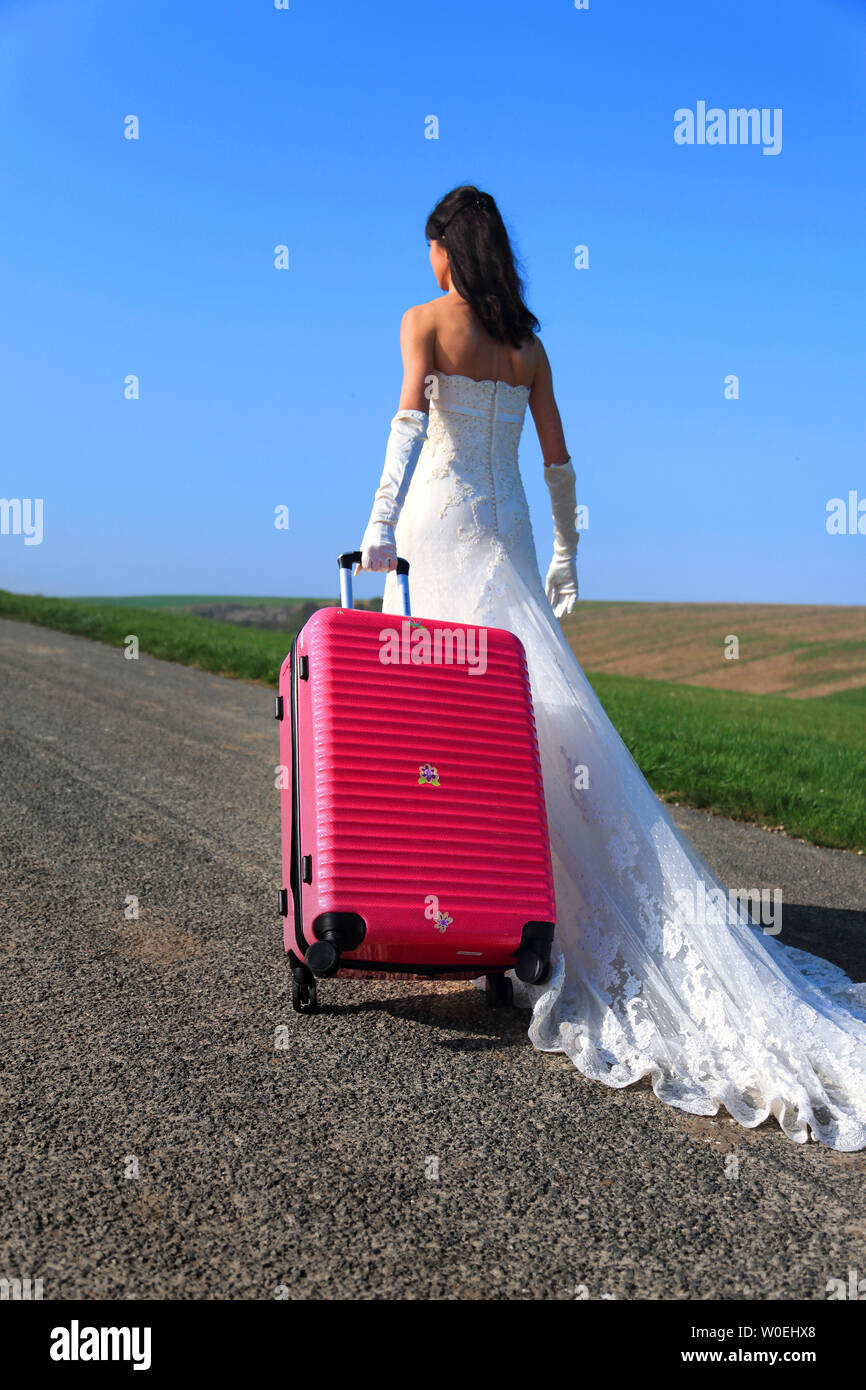 Novia autostop con maleta rosa Foto de stock