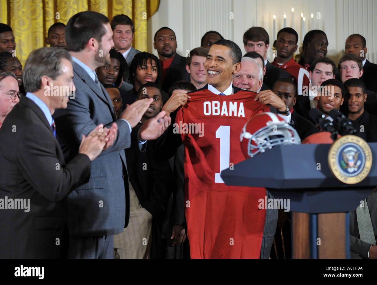 El presidente Barack Obama sostiene una camiseta durante una ceremonia de bienvenida al Campeón Nacional de BCS NCAA Alabama Crimson Tide a la Casa Blanca en Washington el 8 de marzo de 2010. UPI/Kevin Dietsch Foto de stock