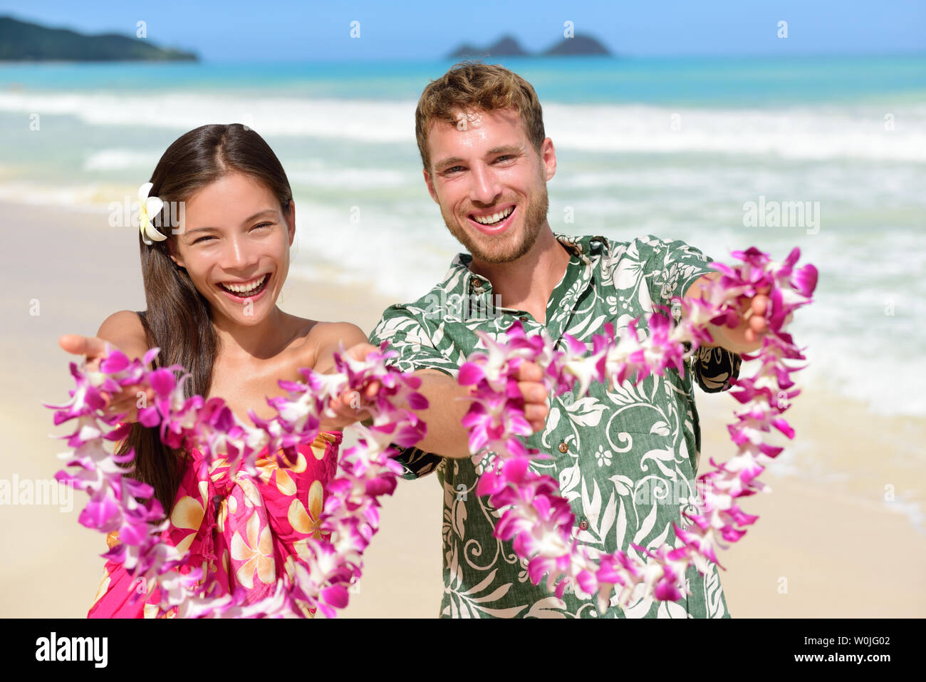 Bienvenido a Hawaii - pueblo hawaiano mostrando leis collares de flores  como un gesto de bienvenida para el turismo. Concepto de vacaciones de  viajes. Mujer Asiática y caucásica y hombre sobre la