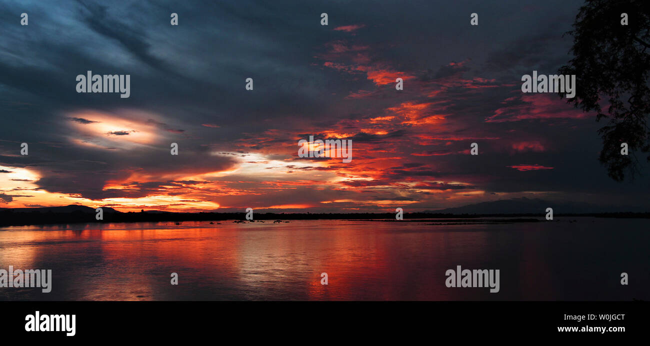 Colores pastel del atardecer se reflejan en las aguas del río Rufiji en la Reserva de Caza Selous, la mayor área silvestre en África Foto de stock