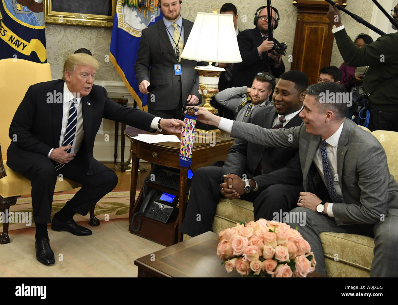 Presidente Donald Trump (L) acepta un par de calcetines de marca de Aflac  employee Michael Porter de Columbus, Georgia (R) durante una reunión con  los trabajadores en la Oficina Oval, en la
