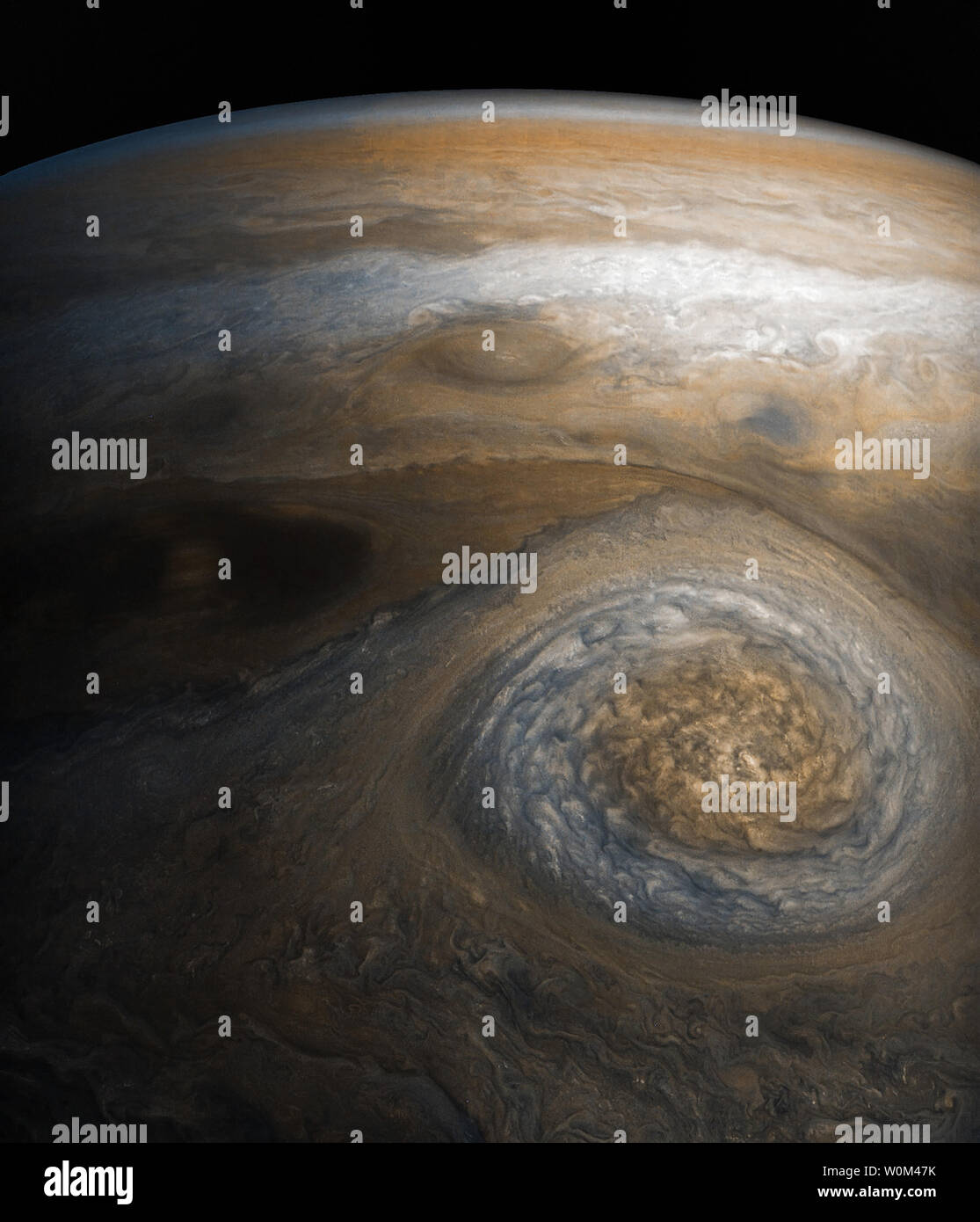 Una tormenta dinámica en el borde sur del norte de la región polar de Júpiter domina esta Jovian cloudscape, cortesía de la NASA la nave de Juno. Esta es una tormenta de larga duración llamado oval anticiclónica al Norte de zonas templadas del norte poco mancha roja 1 (NN-LRS-1); ha sido rastreados por lo menos desde 1993 y pueden ser aún mayores. Un anticiclón es un fenómeno meteorológico donde se enrosca alrededor de la tormenta, el flujo en la dirección opuesta a la del flujo alrededor de una región de baja presión. Es la tercera más grande en el planeta oval anticiclónicas, típicamente alrededor de 3.700 millas (6.000 kilómetros) de largo. El color varía entre el rojo Foto de stock