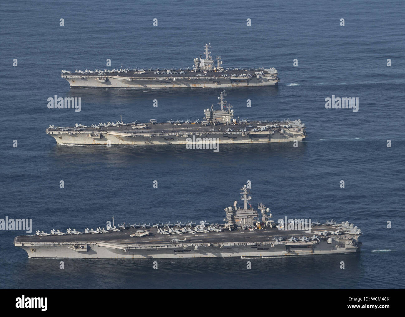 El portaaviones USS Ronald Reagan (CVN 76), USS Theodore Roosevelt (CVN 71) y el USS Nimitz (CVN 68) y sus grupos de huelga están en curso, la realización de las operaciones, en aguas internacionales, como parte de un tres-carrier Strike Force ejercicio el 12 de noviembre de 2017. La marina estadounidense ha patrullado las Indo-Asia Pacífico rutinariamente durante más de 70 años de promoción de la seguridad regional, la estabilidad y la prosperidad. Foto por el Teniente James Griffin/U.S. Navy/UPI Foto de stock