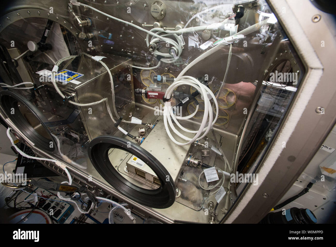Miembros de la tripulación de la Estación Espacial Internacional re-instala la primera impresora 3D en órbita, durante la semana del 27 de junio de 2016, para continuar con la investigación sobre el desarrollo de la tecnología y cómo puede utilizarse en el espacio. El astronauta de la NASA Jeff Williams instalado la impresora en la Caja Guante de las Ciencias de Microgravedad para comenzar otra ronda de ejemplo genera para la impresión en 3D de la NASA en Gravedad Cero una demostración de tecnología. La impresora 3D, entregados originalmente a la estación y probado en 2014, calienta una relativamente baja temperatura de filamento de plástico para construir piezas capa por capa usando diseños suministrada a la máquina. NASA/UPI Foto de stock
