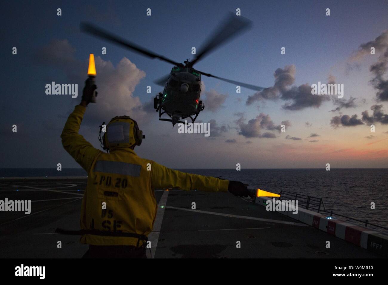 Petty oficial de 2ª clase Torien Collins, un compañero boatswainÕs aviación, dirige un Marine Corps UH-1Y Venom "Huey" helicóptero desde medio marino Tiltrotor Escuadrón 262 (reforzado), 31ª Unidad Expedicionaria de los Infantes de Marina, para despegar desde la cubierta de vuelo del USS Green Bay (LPD-20), en el mar, el 23 de agosto de 2016. Foto por J. Darien Bjorndal/U.S. Marine Corps/UPI Foto de stock