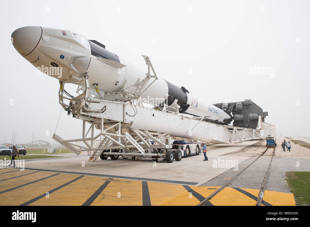 Un cohete SpaceX Falcon 9 con la empresa de la tripulación a bordo de la nave dragón es visto como se desenrolle del mecanismo de integración horizontal en el complejo de lanzamiento 39A medida que continúan los preparativos para la demostración-1 la misión, el 28 de febrero de 2019, en el Centro Espacial Kennedy en Florida. La Demo-1 misión será el primer lanzamiento de un construidas y explotadas comercialmente espaciales y naves espaciales americanos sistema diseñado para los seres humanos como parte del programa de tripulación comercial de la NASA. La misión, dirigida por un lanzamiento de 2:49am el 2 de marzo, sirva de principio a fin una prueba de la capacidad del sistema. Foto de la NASA por Joel K Foto de stock