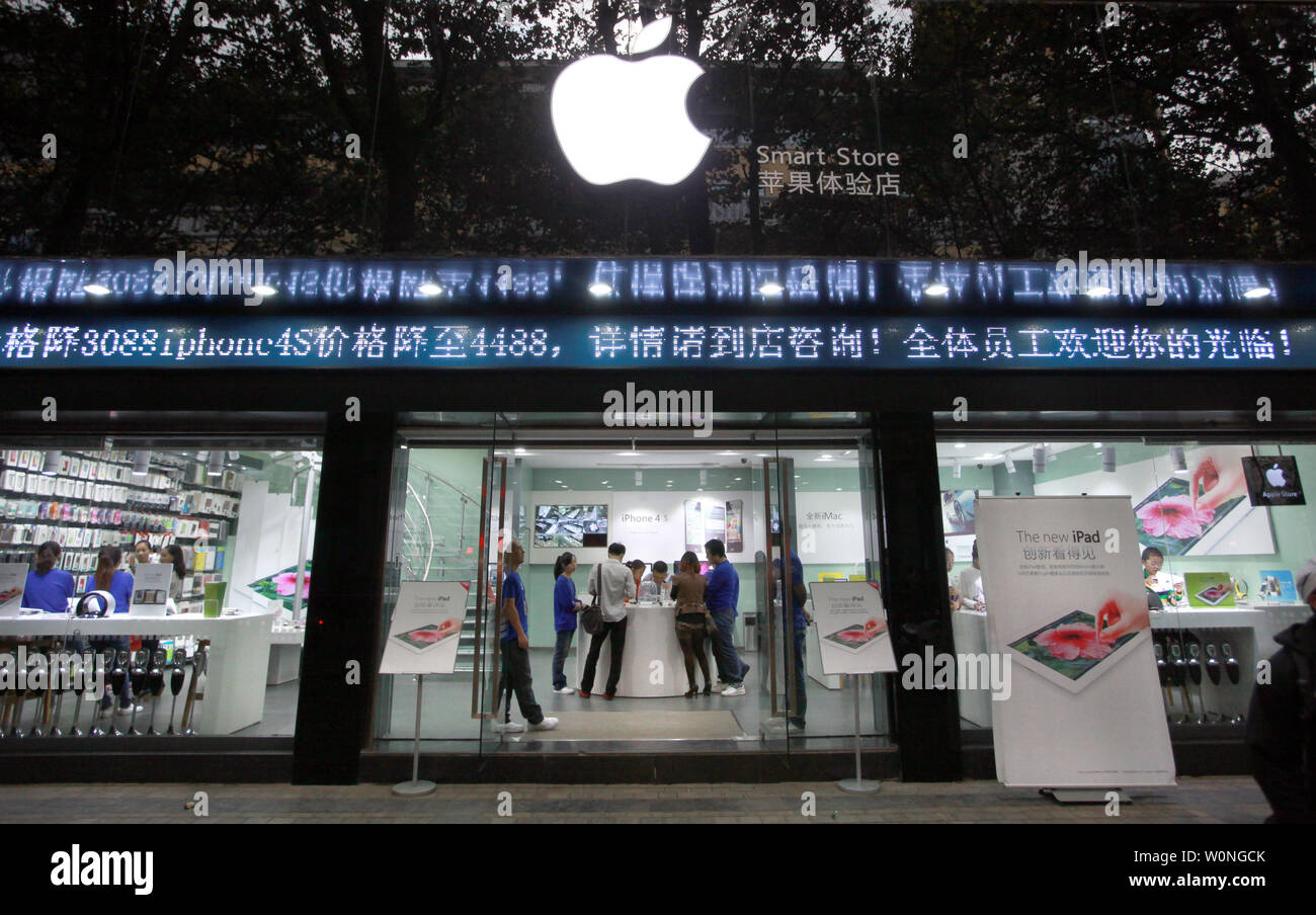 Los empleados chinos vestidos como oficiales de Apple al personal a trabajar en una tienda de informática que pregonaba flagrantemente a sí mismo como un oficial "inteligente Apple Store, los clientes de venta real y 'Gris' los productos de Apple en Kunming, la capital de la provincia de Yunnan, el 24 de septiembre de 2012. Kunming tiene varias tiendas 'Apple' el año pasado de cesar y desistir a despreciar abiertamente las infracciones de copyright y marcas comerciales. En el caso de stands, muchas veces una demostración de fuerza por parte del gobierno para atacar y resolver esos problemas suele ser sólo temporal con el fin de apaciguar a los reclamantes. UPI/Stephen afeitadora Foto de stock