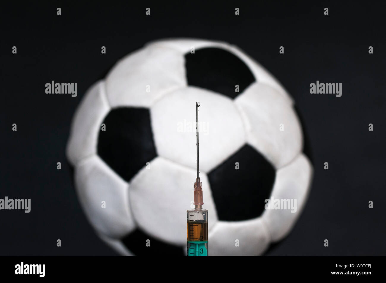 Vor einem Fussball ist eine Spritze im, el dopaje deportivo. Foto de stock