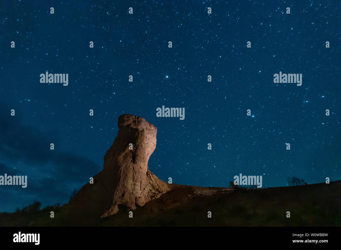 Pilar de piedra bajo el cielo estrellado en las montañas Emel Altyn Aktau, Kazajstán, Parque Nacional Foto de stock
