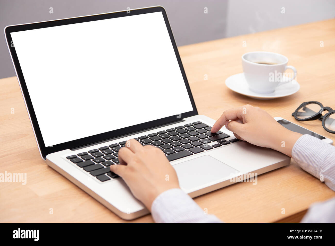 La empresaria trabaja con ordenador portátil, con el dedo con el teclado para escribir. un ordenador portátil con pantalla en blanco para copiar el espacio Foto de stock