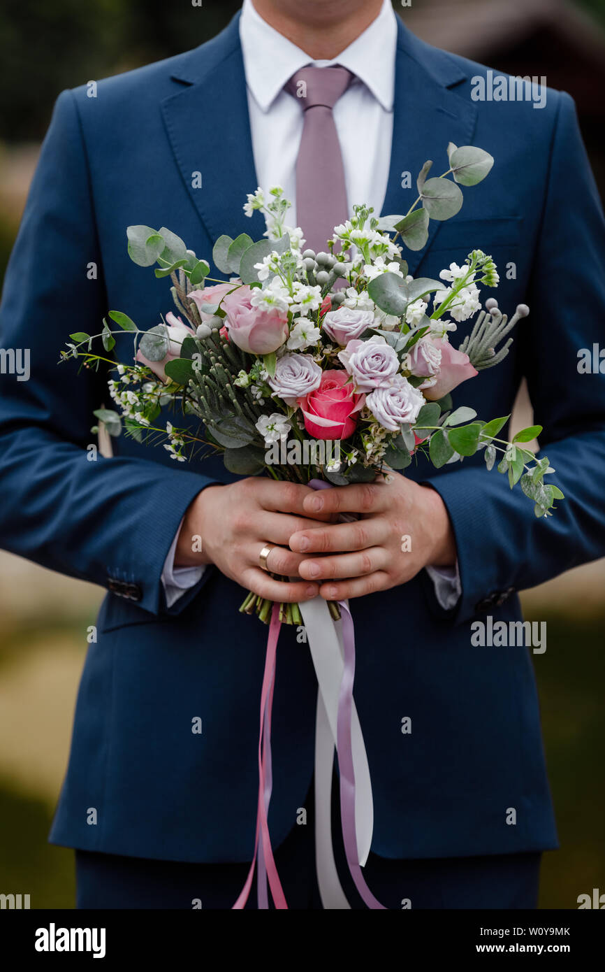 Se mantiene el novio elegante ramo de novia. Bouquet de boda en manos del  hombre Fotografía de stock - Alamy
