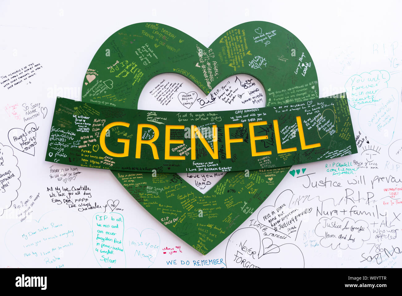 Obras de arte con motivos de corazón verde en la muralla conmemorativa de la Torre Grenfell. Foto de stock