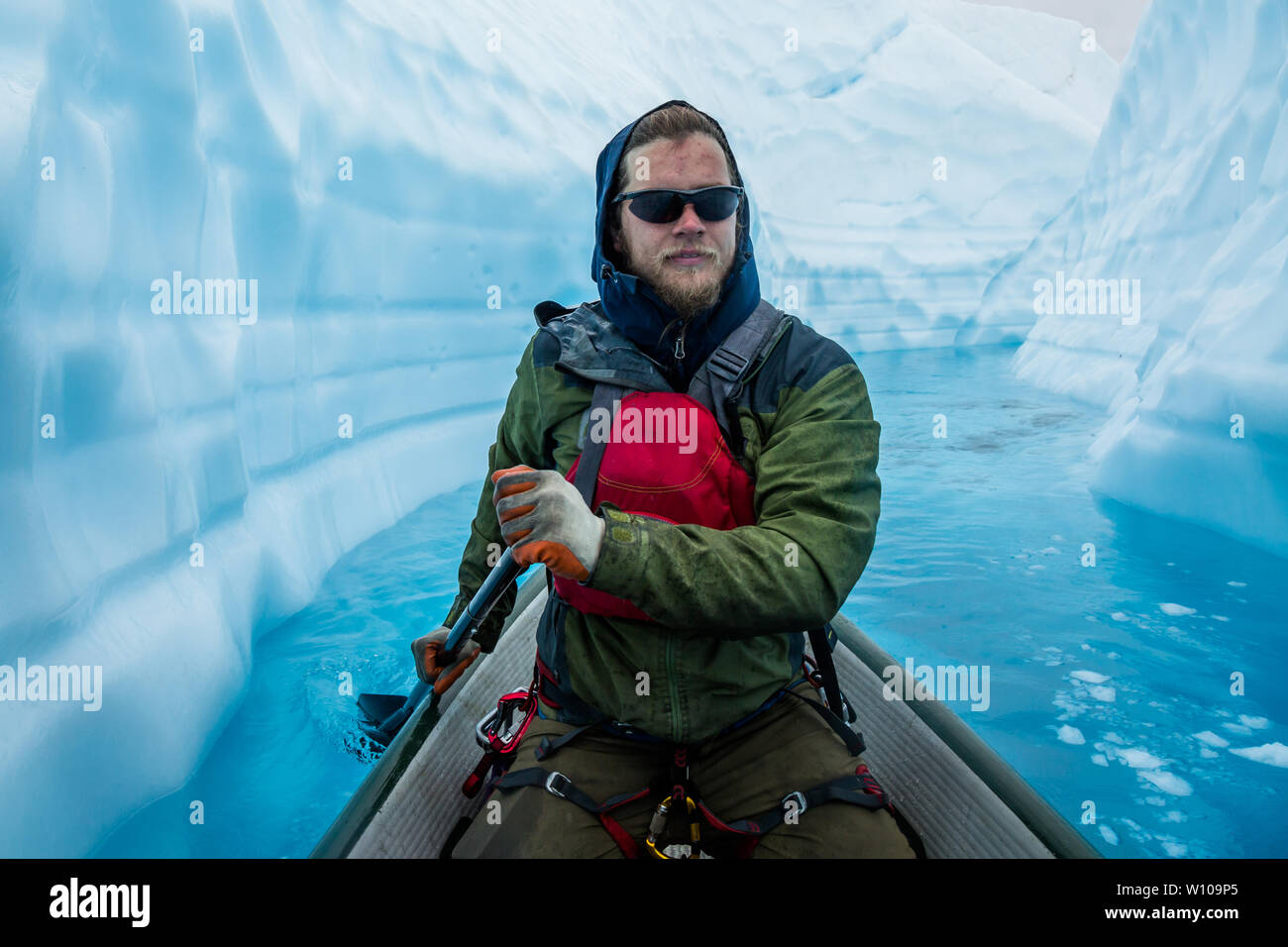 Escalador de hielo se centró en remando a través de un estrecho cañón de hielo en la parte superior del Glaciar Matanuska en Alaska. Foto de stock