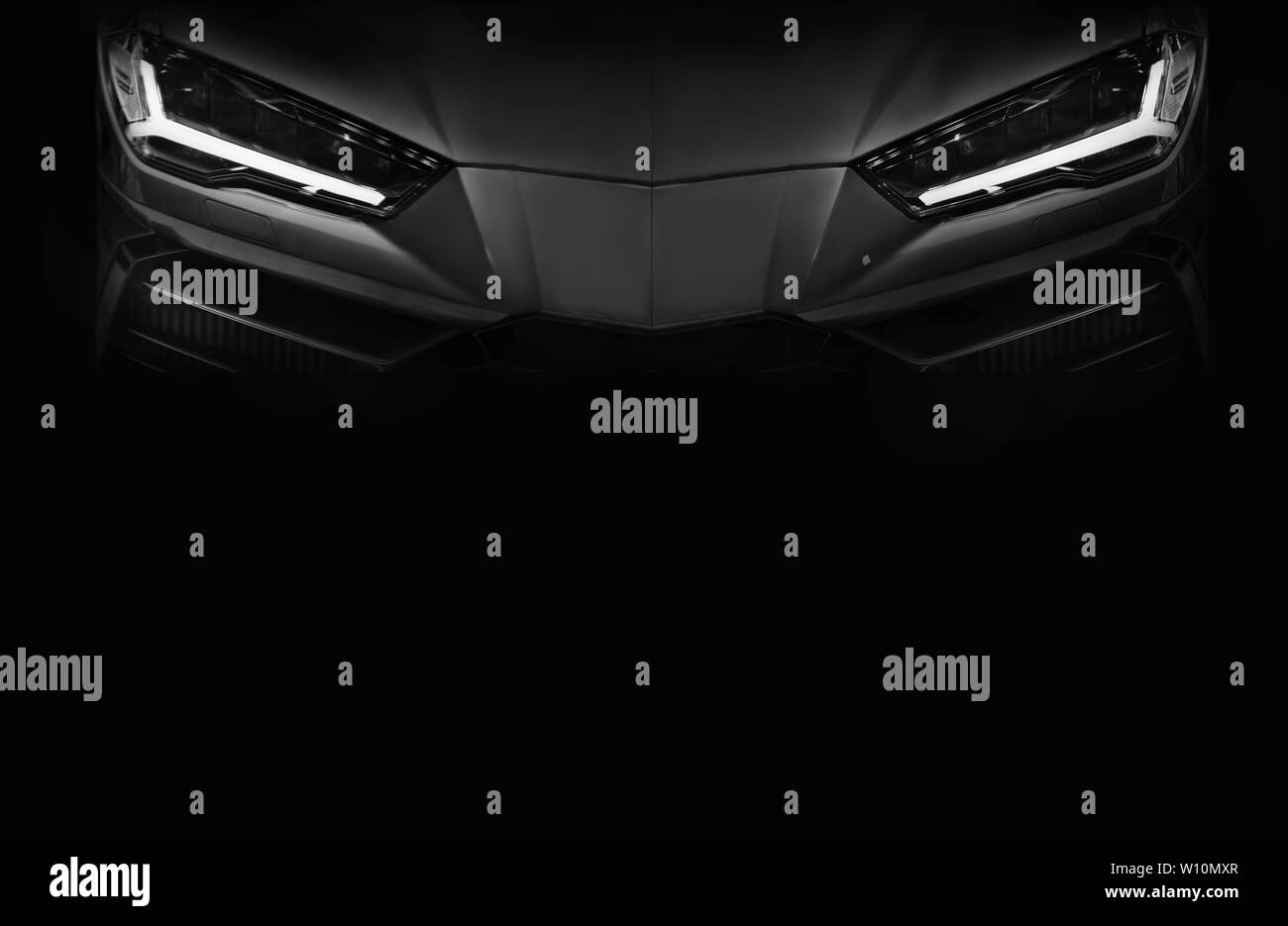 Silueta de negro coche deportivo con faros LED sobre fondo negro,espacio de copia Foto de stock