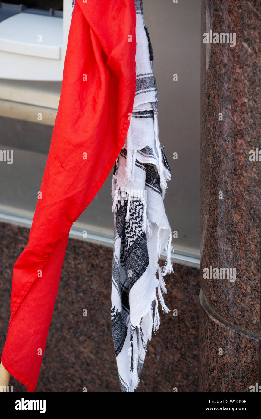 Palestino keffiyeh y bandera comunista en las calles de Europa Foto de stock